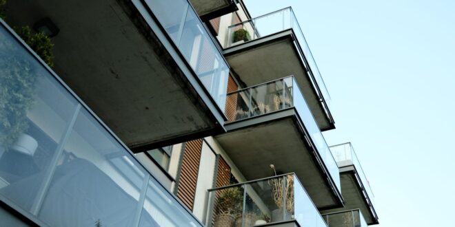 Balkone mit Glasbrüstungen an einem Wohnhaus von unten gesehen