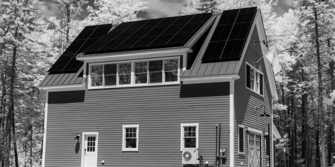 Wohnhaus mit Solaranlage auf dem Dach in Schwarzweiß