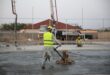 Bauarbeiter glättet frisch eingebrachten Estrich auf einer Baustelle mit einer Glättmaschine