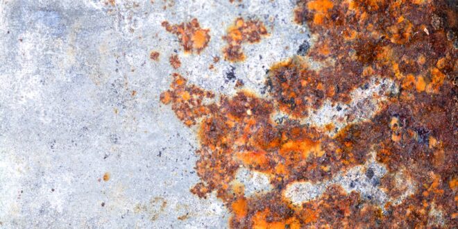 Orangefarbener Rost und Korrosion auf einer Metalloberfläche