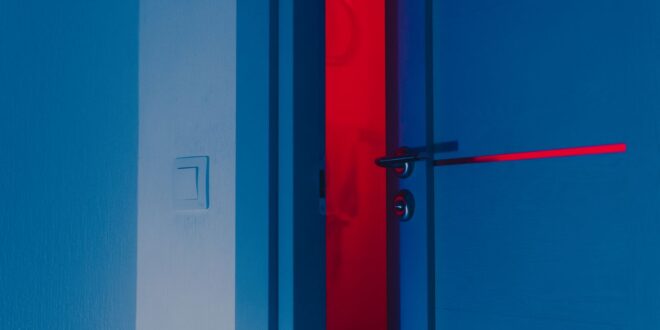 Innentür mit Türklinke und Zarge in blauem und rotem Licht