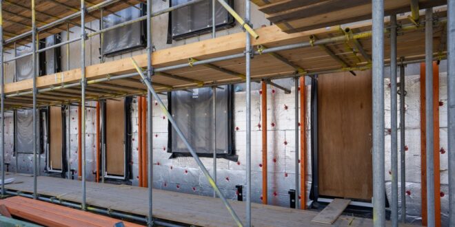 Gedämmte Gebäudefassade mit Dämmplatten und Fensteröffnungen während der Sanierung